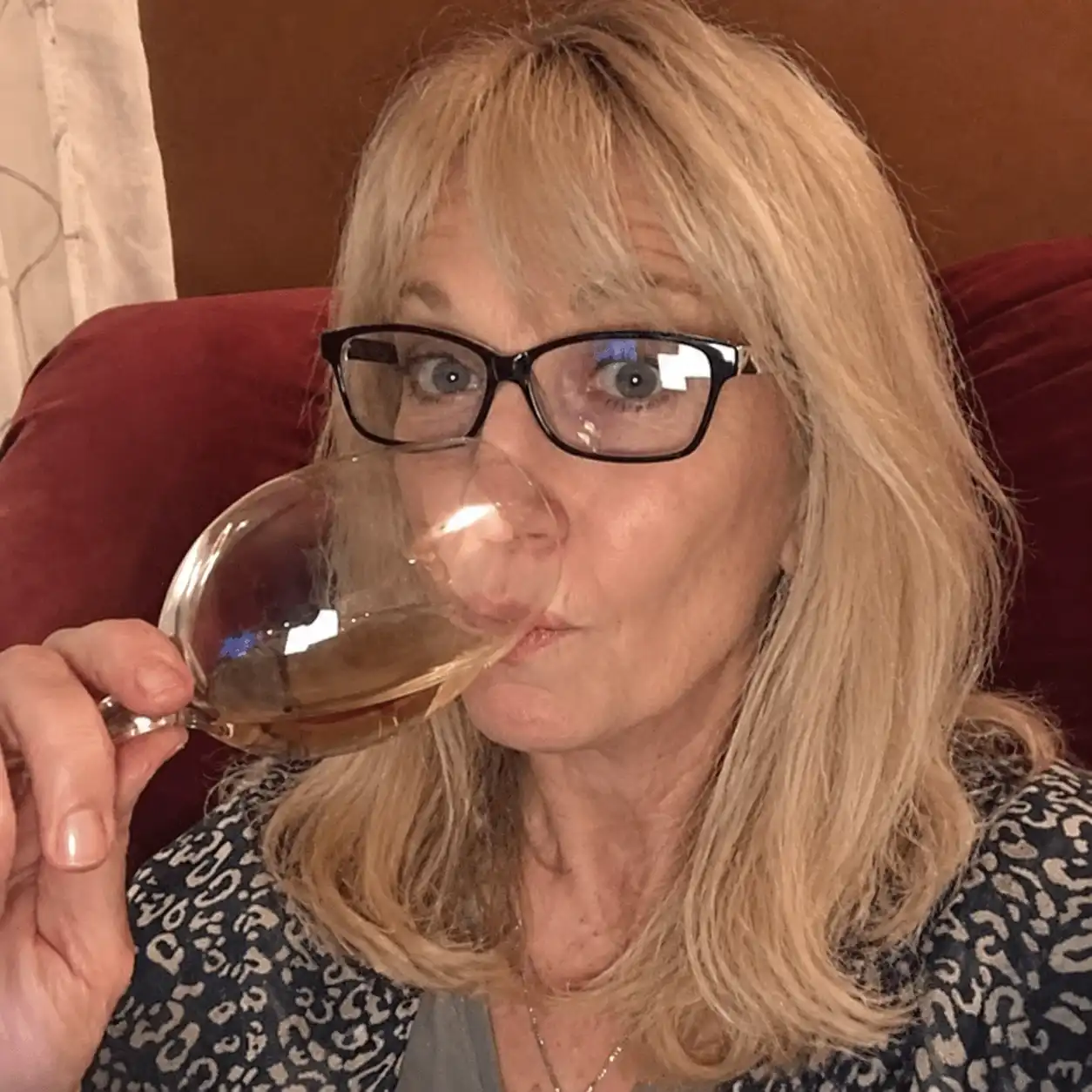 A glass of wine poured in a quiet kitchen at dusk