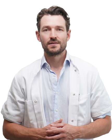 Man in a white lab coat with folded hands.