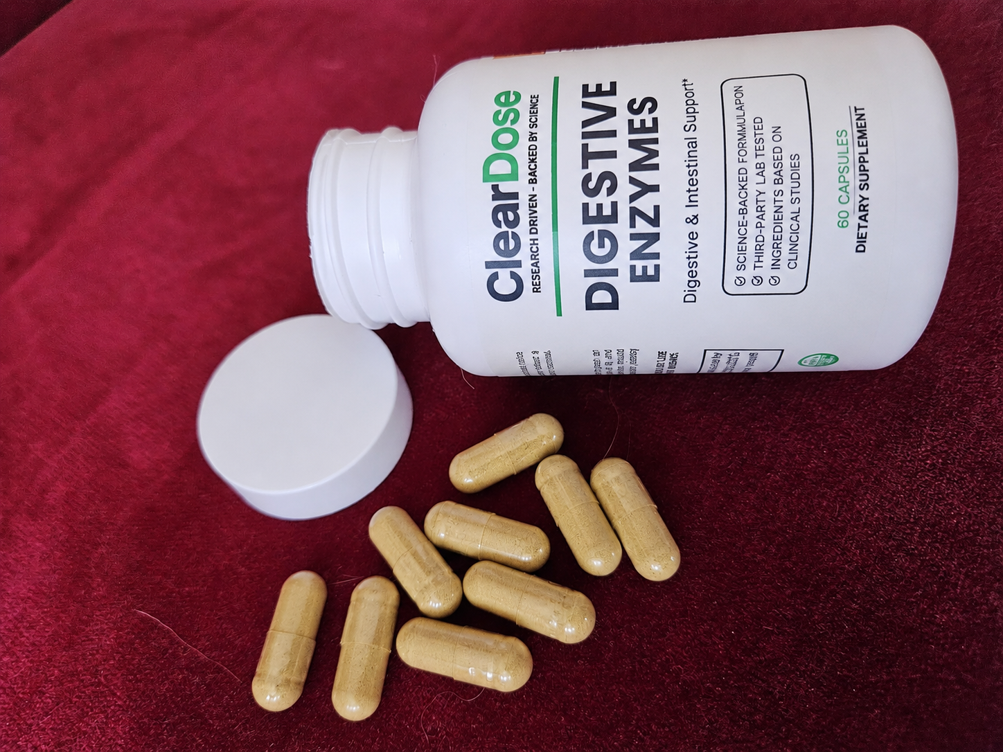 A bottle of ClearDose Digestive Enzymes with capsules beside it