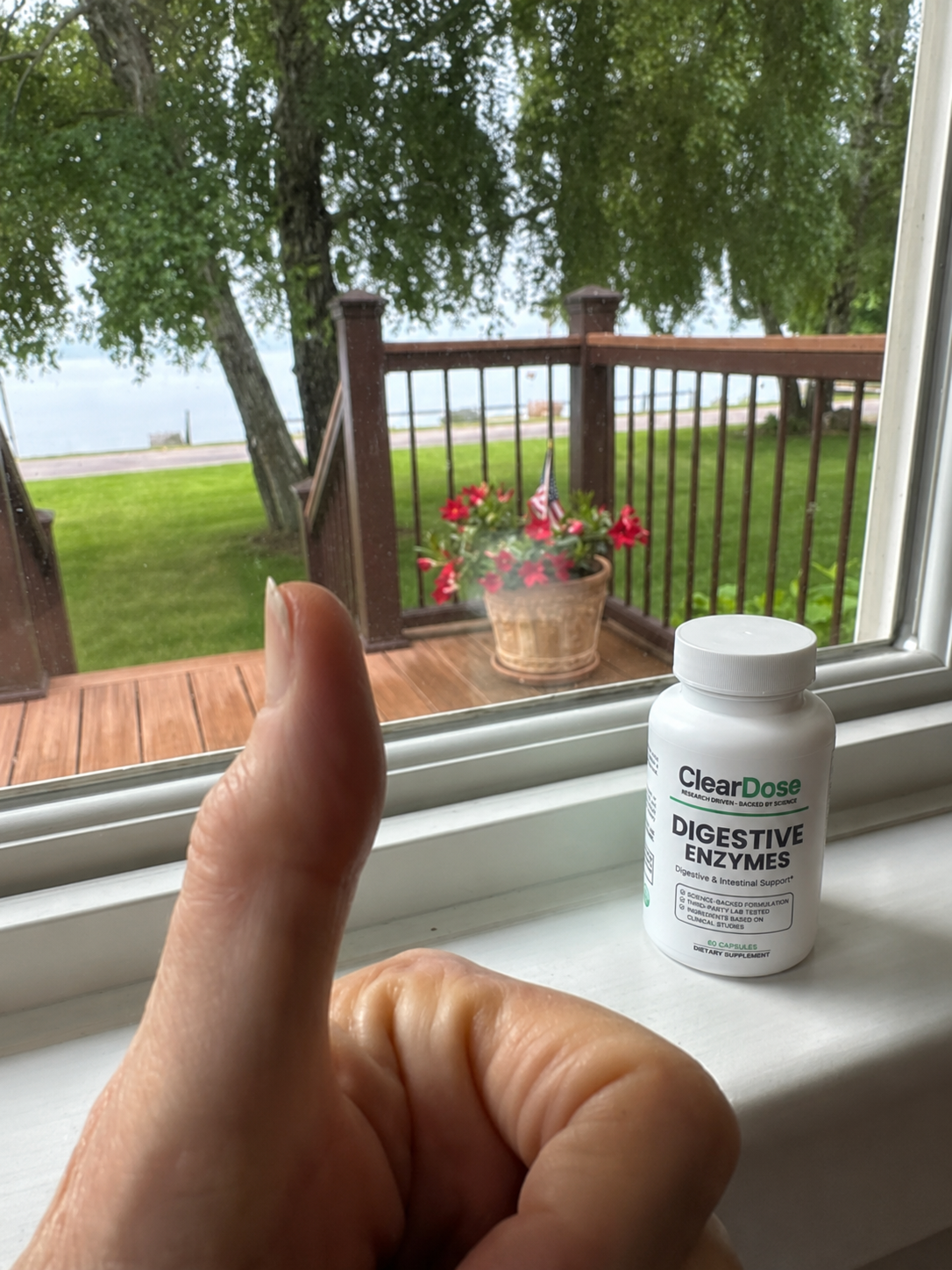 A thumbs up beside a bottle of ClearDose Digestive Enzymes on a windowsill