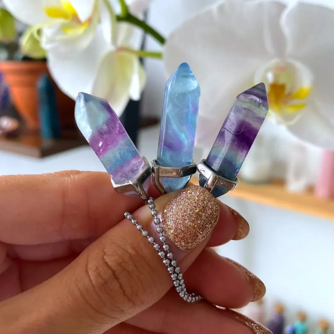 Hand holding a fluorite crystal necklace