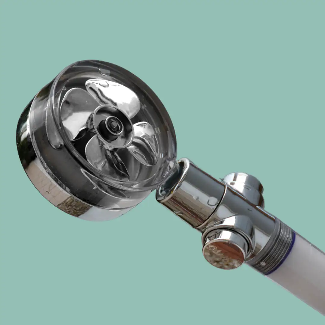 Chrome shower head with a propeller design on a teal background.
