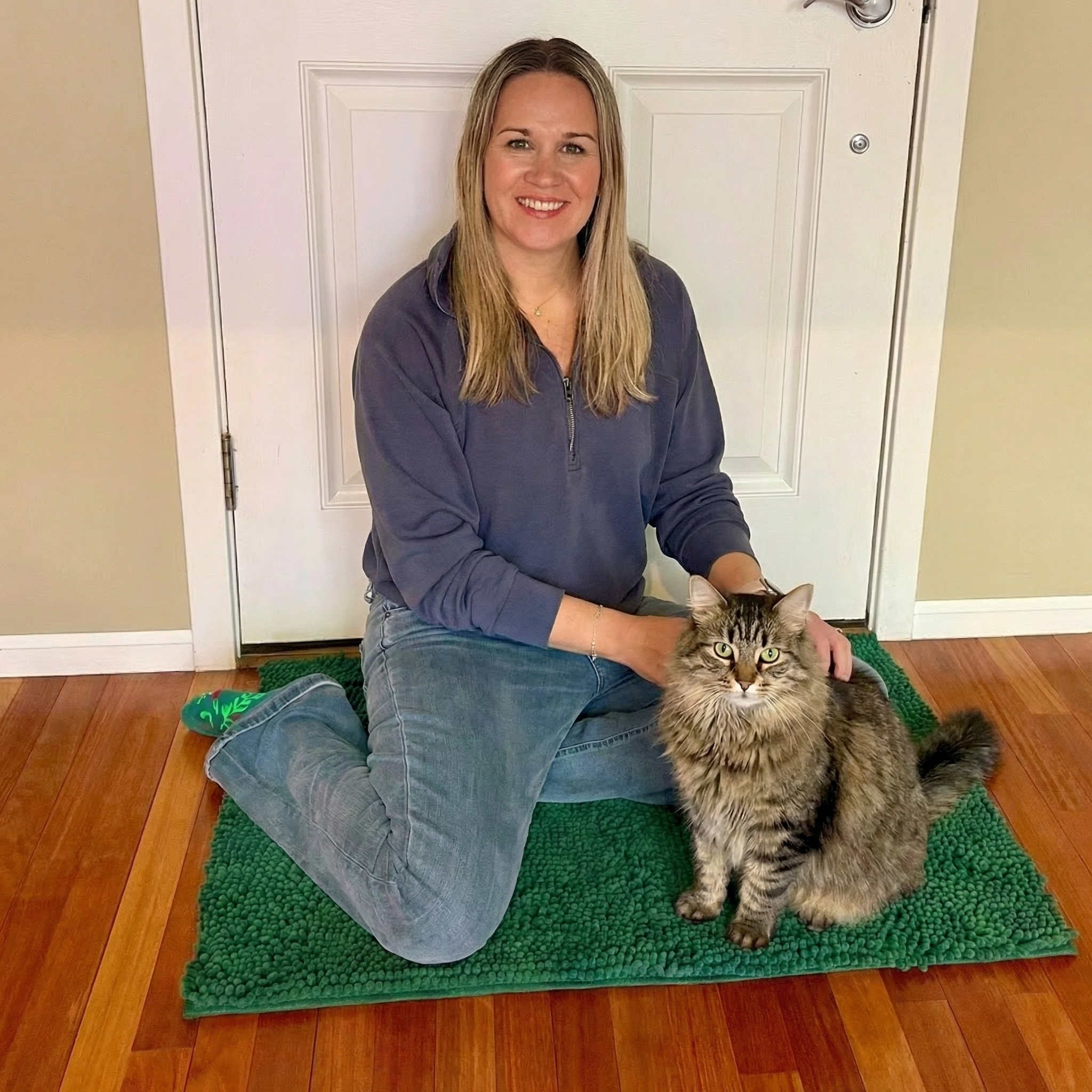 Happy cat owner sitting with cat on Muddy Mat