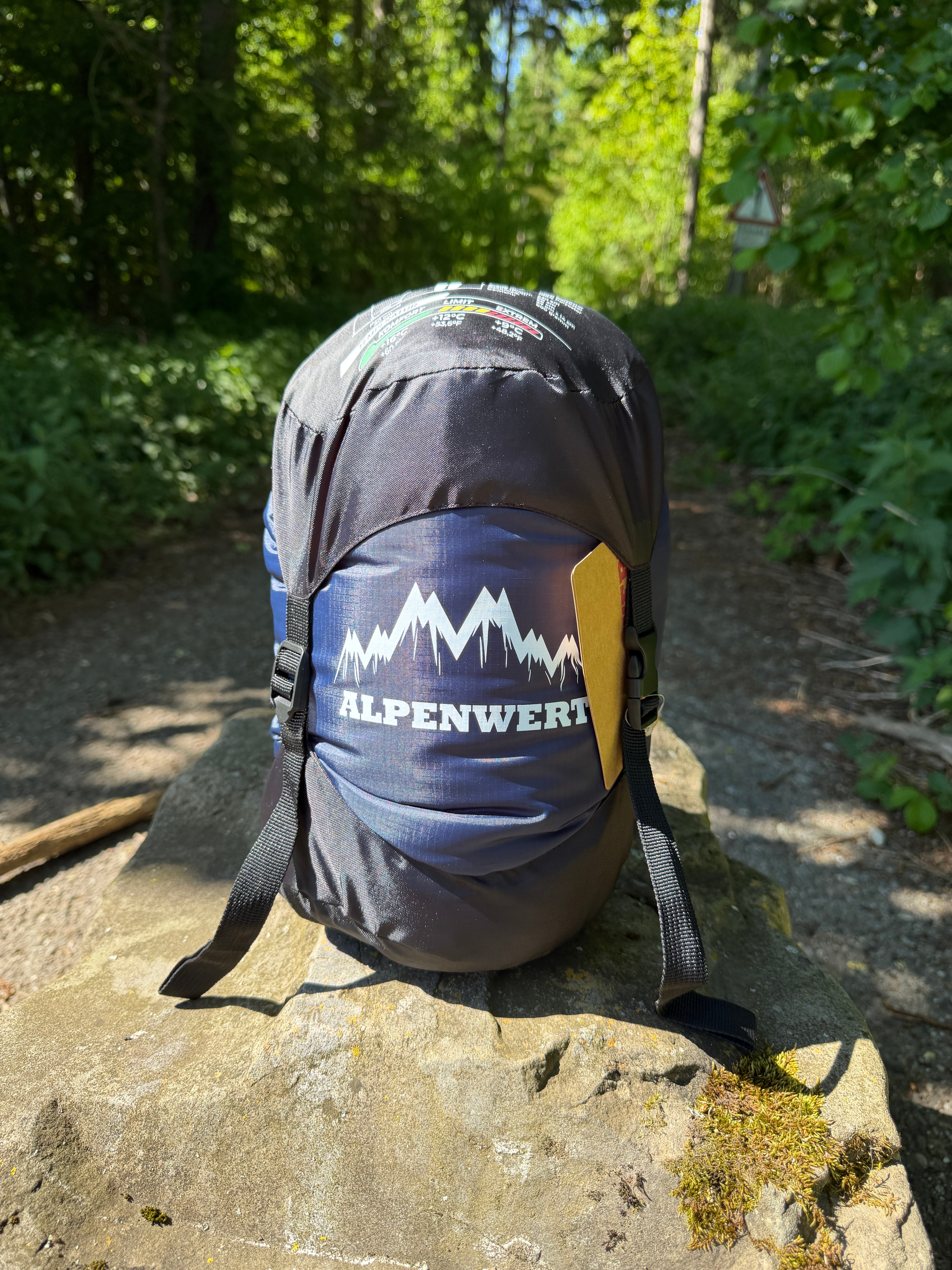ALPENWERT Sommerschlafsack kompakt verpackt im Wald