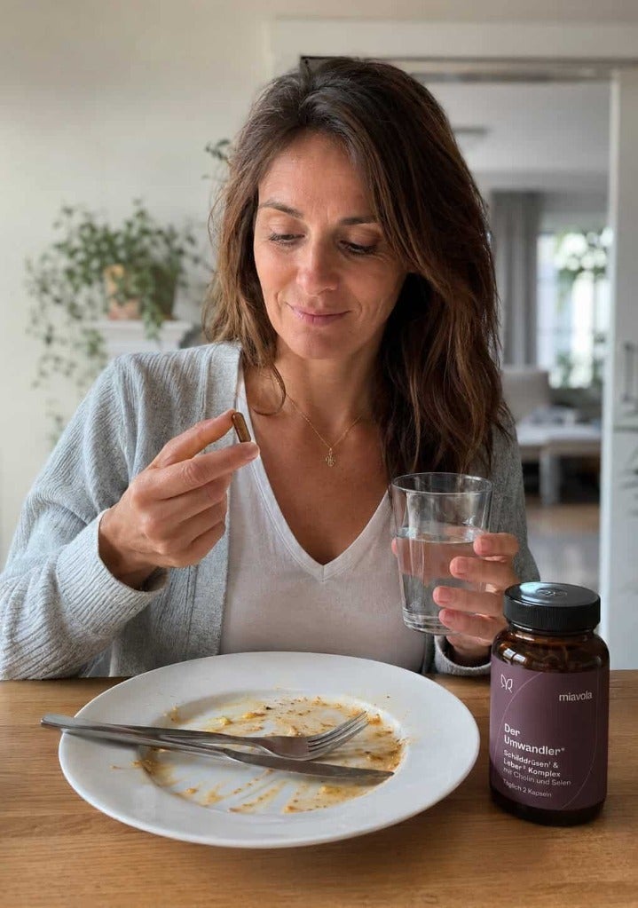 Kvinde tager ThyroBoost™ med vand